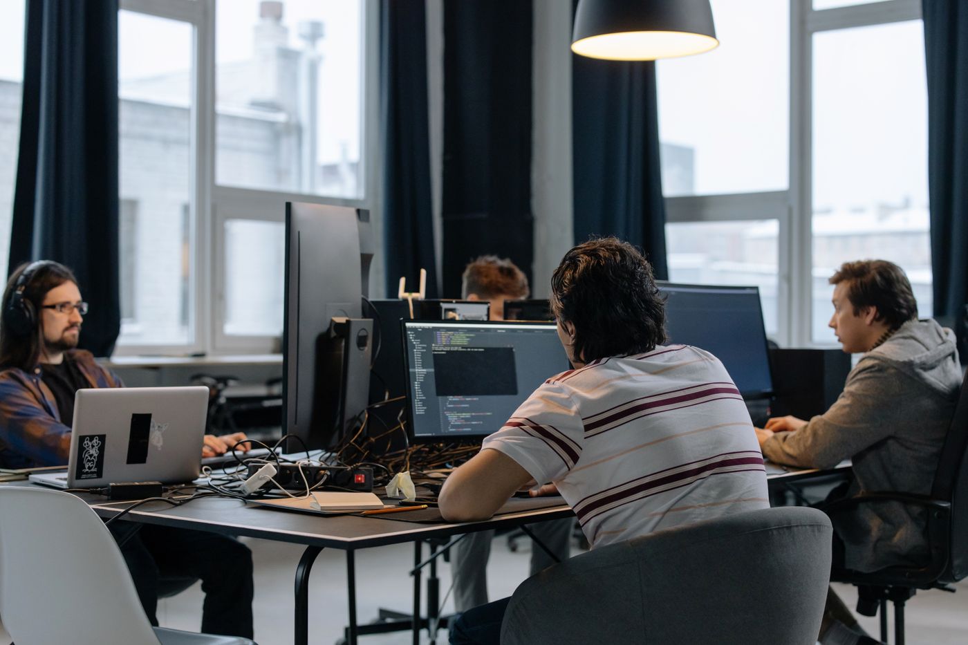 A technology company development team working across multiple monitors