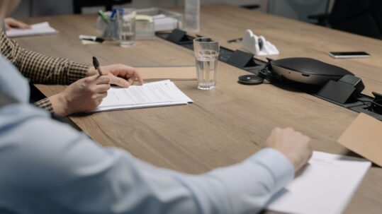 Finance and contracts professionals reviewing a government contract at a conference table