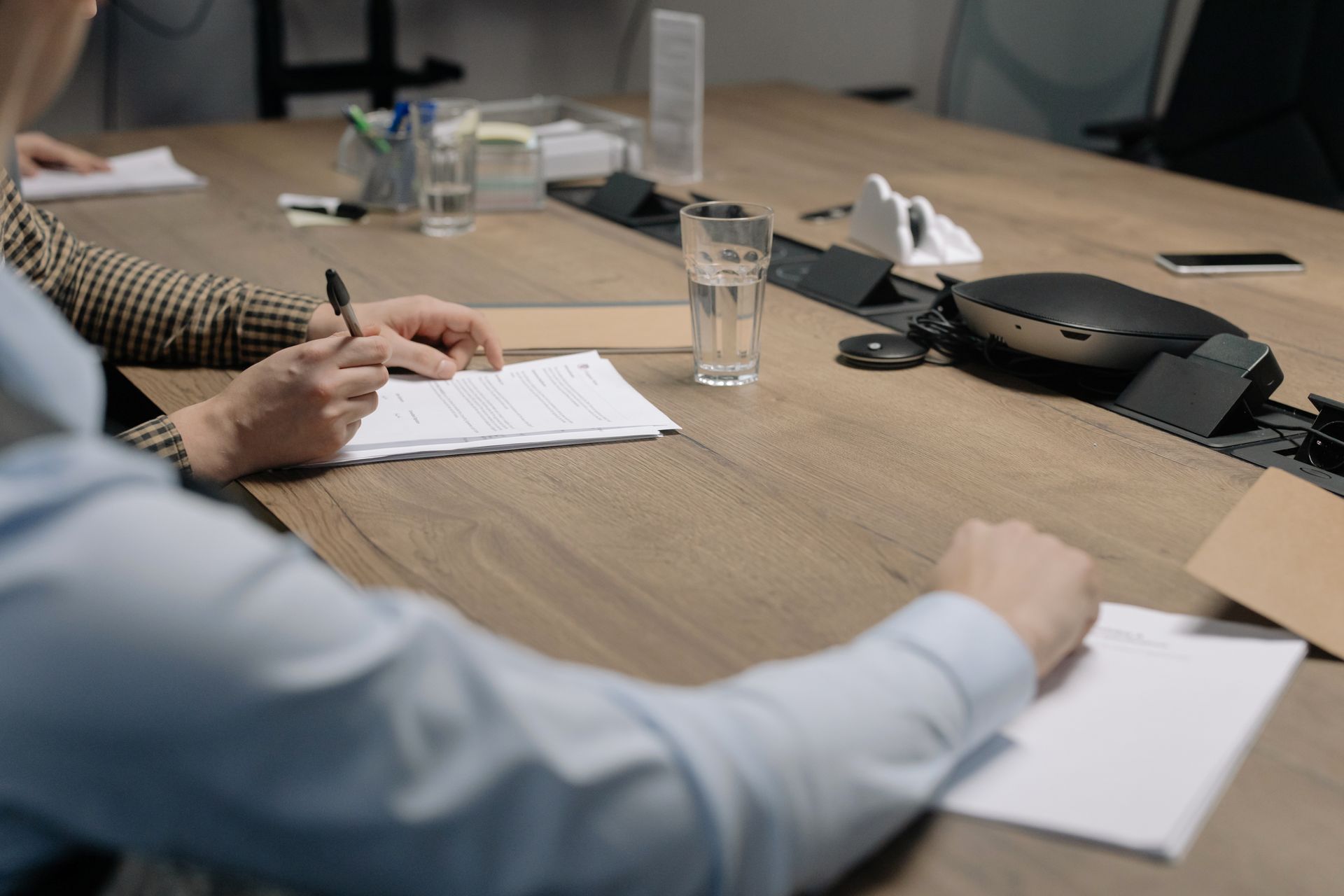 Finance and contracts professionals reviewing a government contract at a conference table